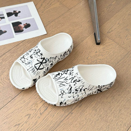 POOL GRAFFITI CROCS SLIDE SANDALS IN WHITE AND BLACK RUBBER