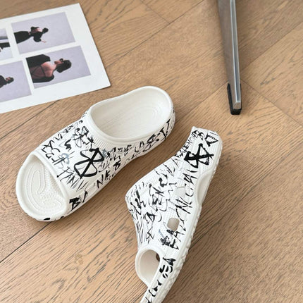 POOL GRAFFITI CROCS SLIDE SANDALS IN WHITE AND BLACK RUBBER