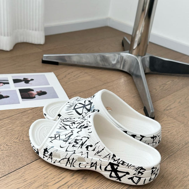 POOL GRAFFITI CROCS SLIDE SANDALS IN WHITE AND BLACK RUBBER