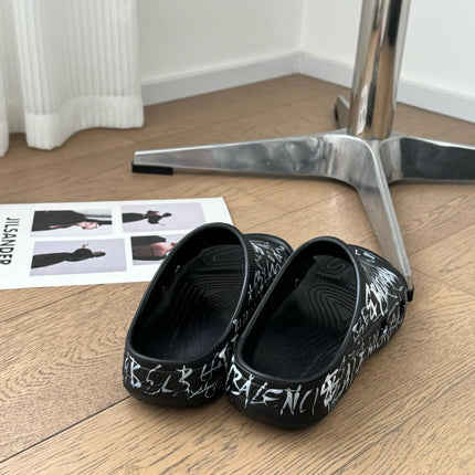 POOL GRAFFITI CROCS SLIDE SANDALS IN BLACK AND WHITE RUBBER