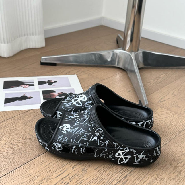 POOL GRAFFITI CROCS SLIDE SANDALS IN BLACK AND WHITE RUBBER