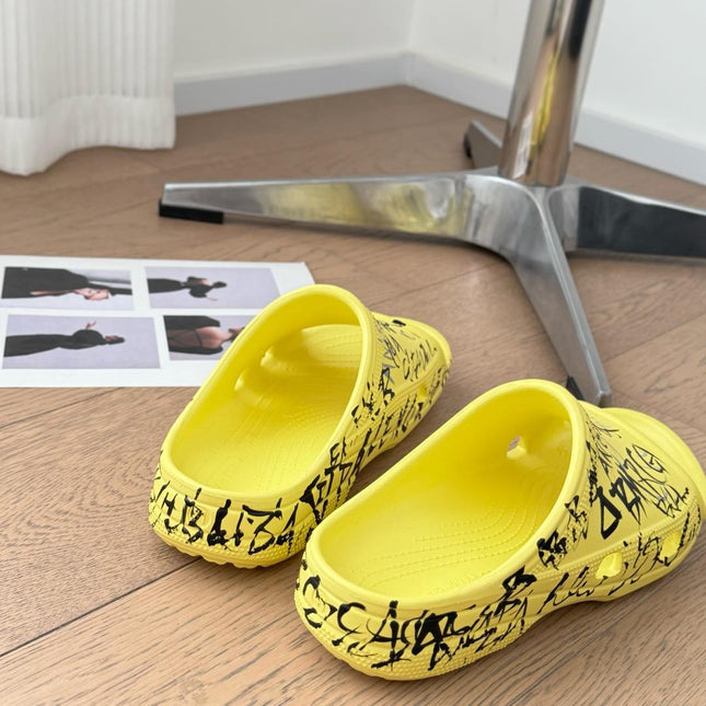 POOL GRAFFITI CROCS SLIDE SANDALS IN YELLOW AND BLACK RUBBER