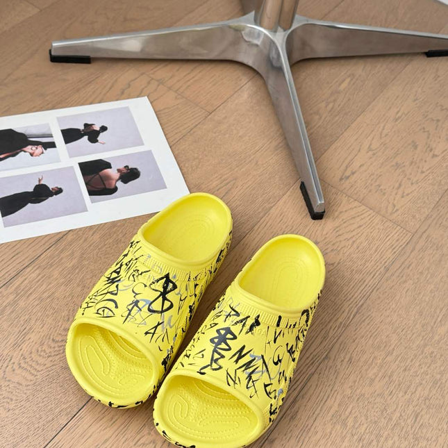 POOL GRAFFITI CROCS SLIDE SANDALS IN YELLOW AND BLACK RUBBER
