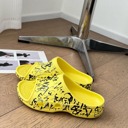 POOL GRAFFITI CROCS SLIDE SANDALS IN YELLOW AND BLACK RUBBER