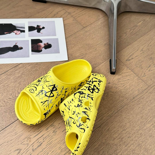 POOL GRAFFITI CROCS SLIDE SANDALS IN YELLOW AND BLACK RUBBER