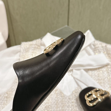 FLAT MULES IN BLACK SMOOTH CALFSKIN GOLD BUCKLE