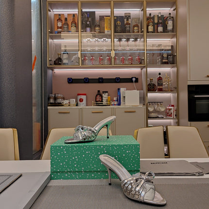 BOW-EMBELLISHED HIGH MULES IN SILVER METALLIC SHEEPSKIN